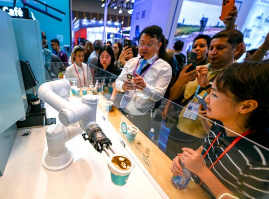 10月15日,在第138届广交会服务机器人专区,展商向观众展示一款商用咖啡机器人设备。新华社记者 肖恩楠 摄